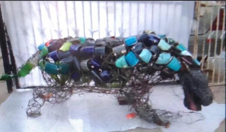 Chameleon covered in blue and teal bottle caps