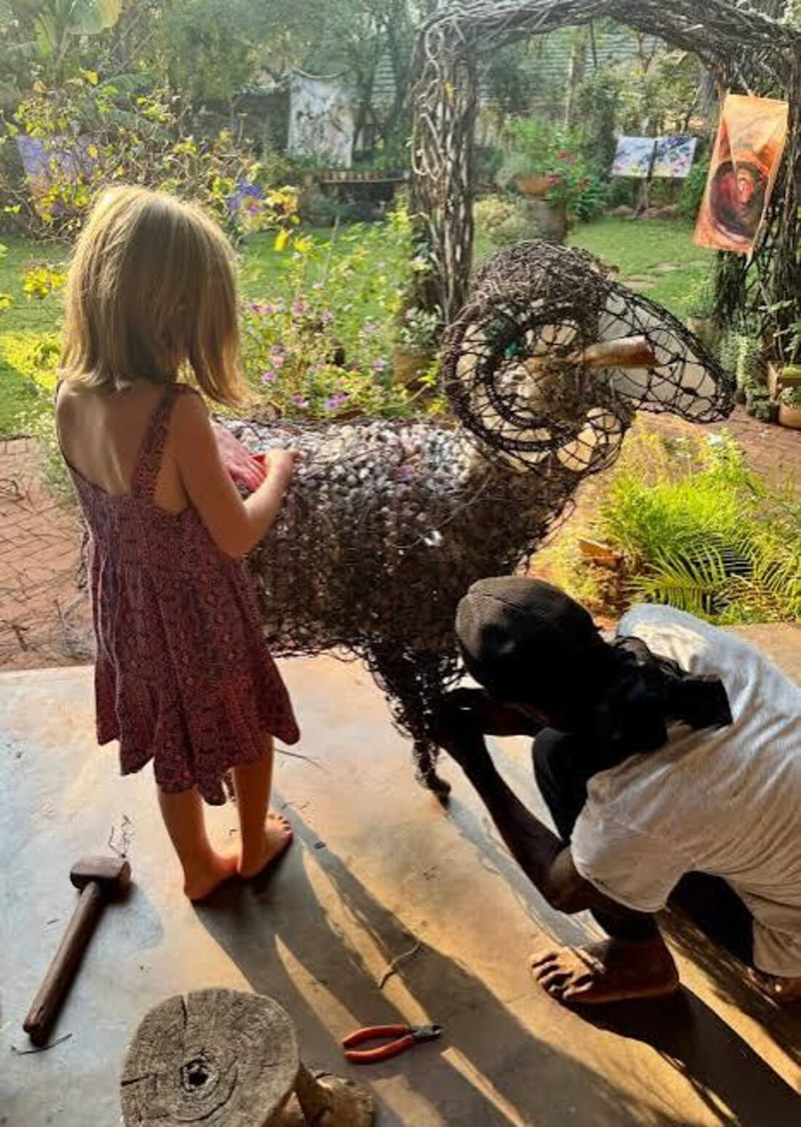 A child meeting a finished wire ram in the studio garden