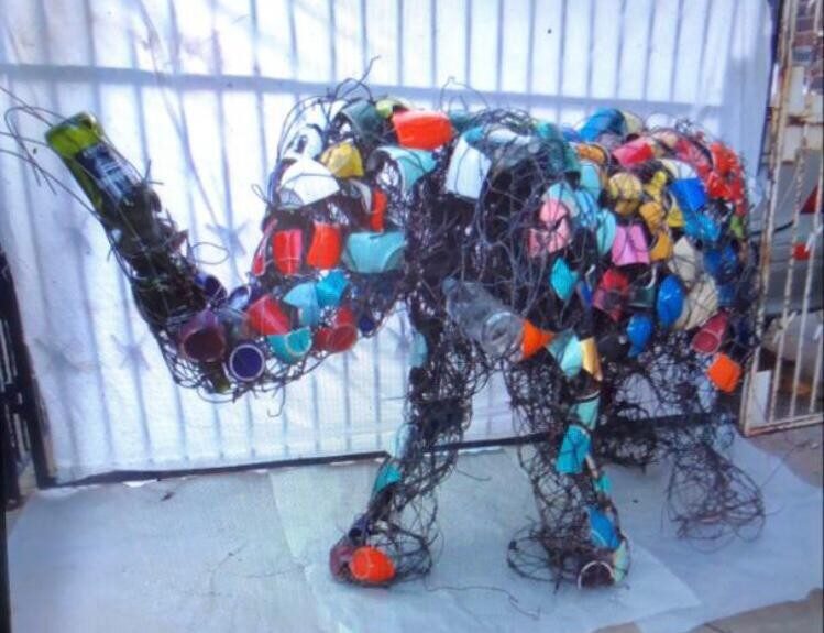 Life-size elephant covered in coloured bottle caps and plastic