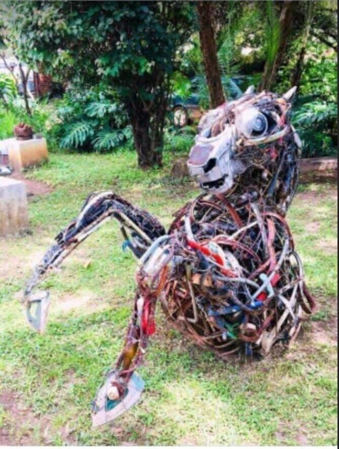 Horse sculpture made from red and black salvaged cable with a found metal head